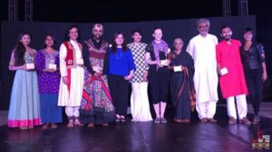 Gillian onstage with diverse performers in cultural and modern dress