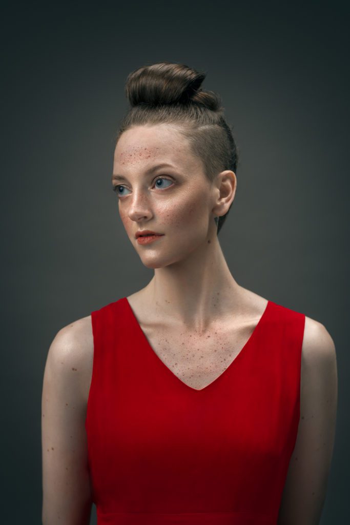 portrait of Gillian in a red dress with a high chignon hairdo