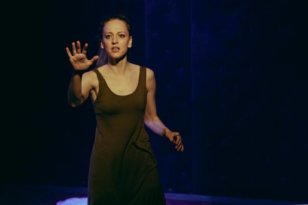 gillian holding out a hand and looking intense during a performance