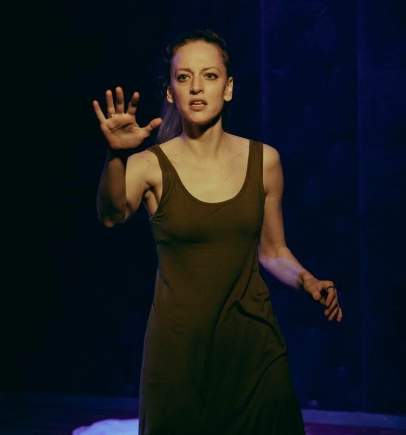 gillian holding out a hand and looking intense during a performance