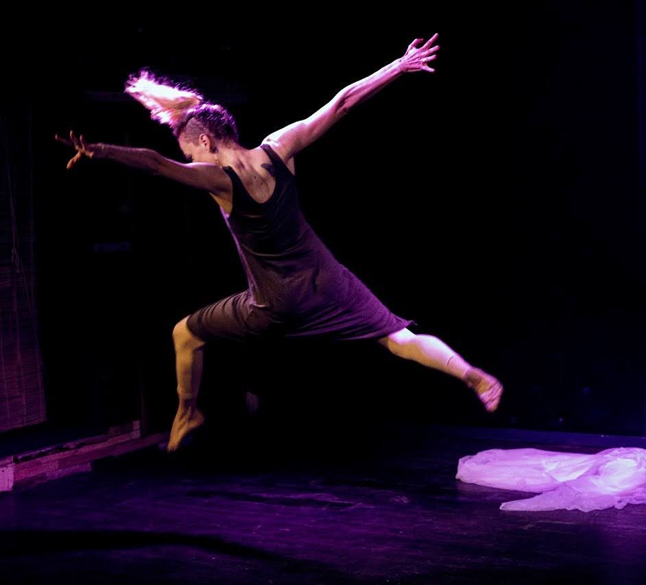 a performer leaping through the air with their back to the camera