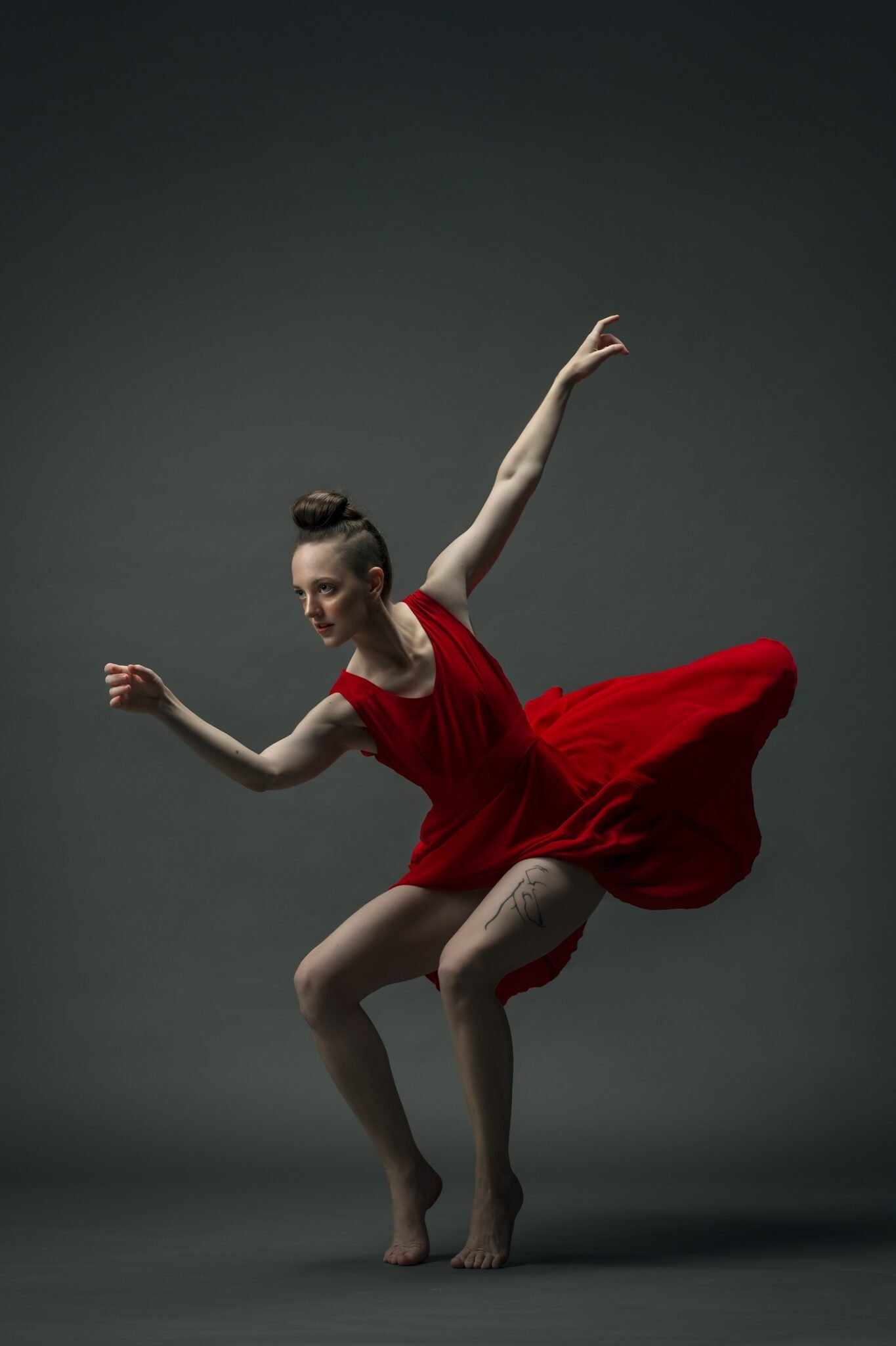 Gillian in a cat like posture in a red dress