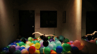 Gillian emerging from a sea of balloons