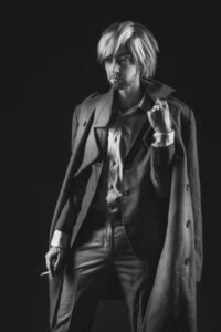 Gillian as a tough mafia type boss man with a jacket and cigarette