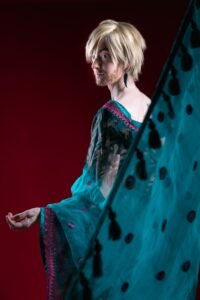 gillian as a man in a sari facing away from the camera and looking back over his shoulder