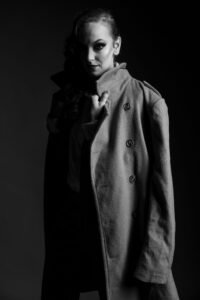 Gillian as a mysterious woman in a long wool coat