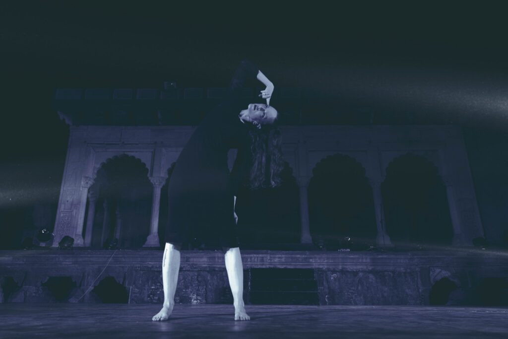 Gillian dancing against a dark dramatic background of the Lahore fort