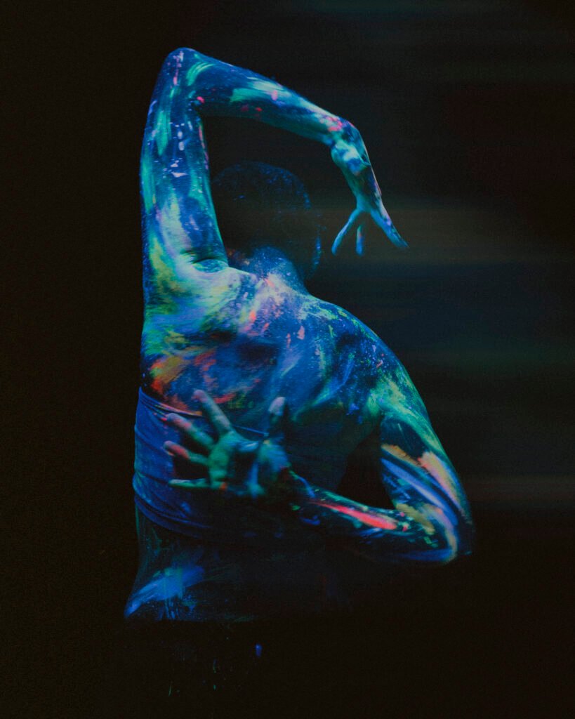 Gillian facing back with glow in the dark paint all over with both hands visible