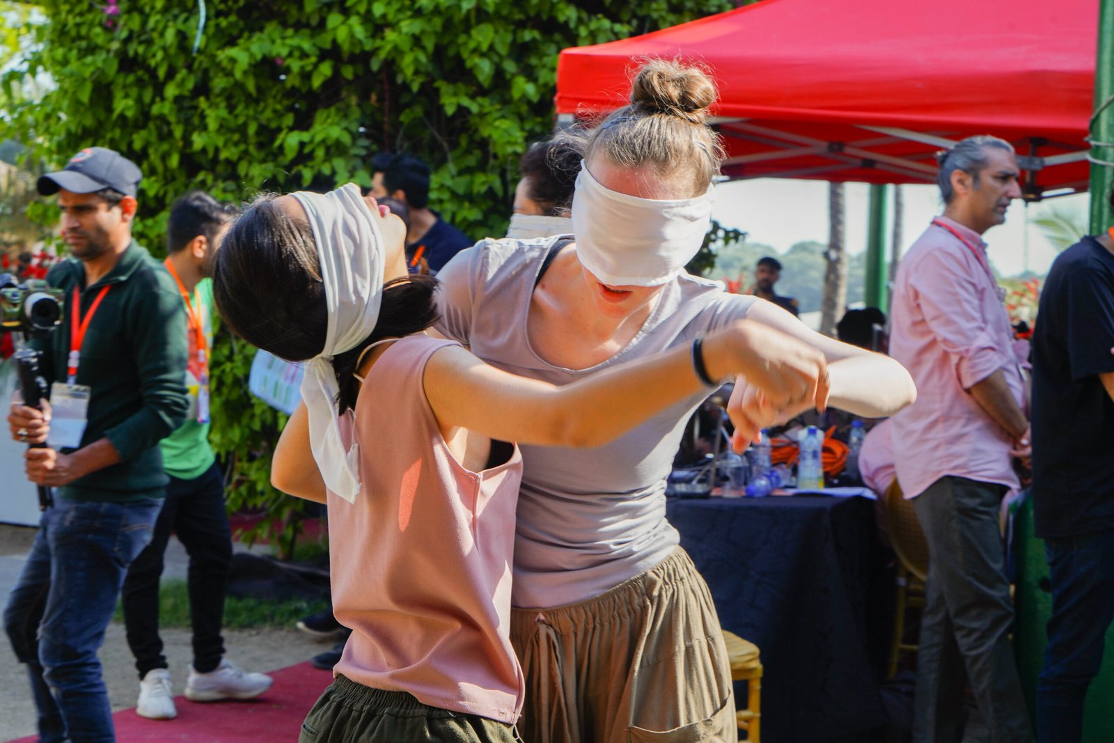 Two women wearing blindfolds and holding each other