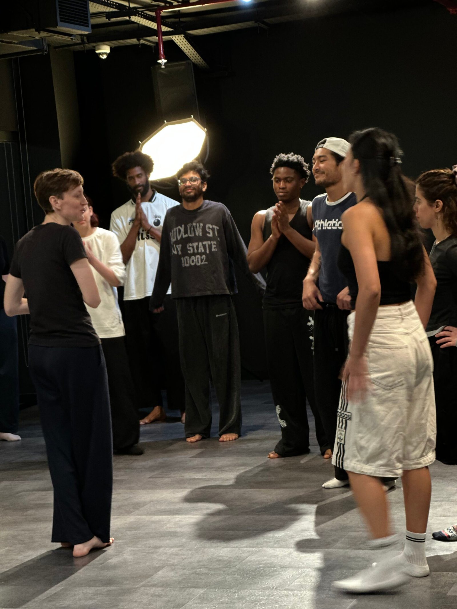 Gillian standing in front of a smiling group in a studio 