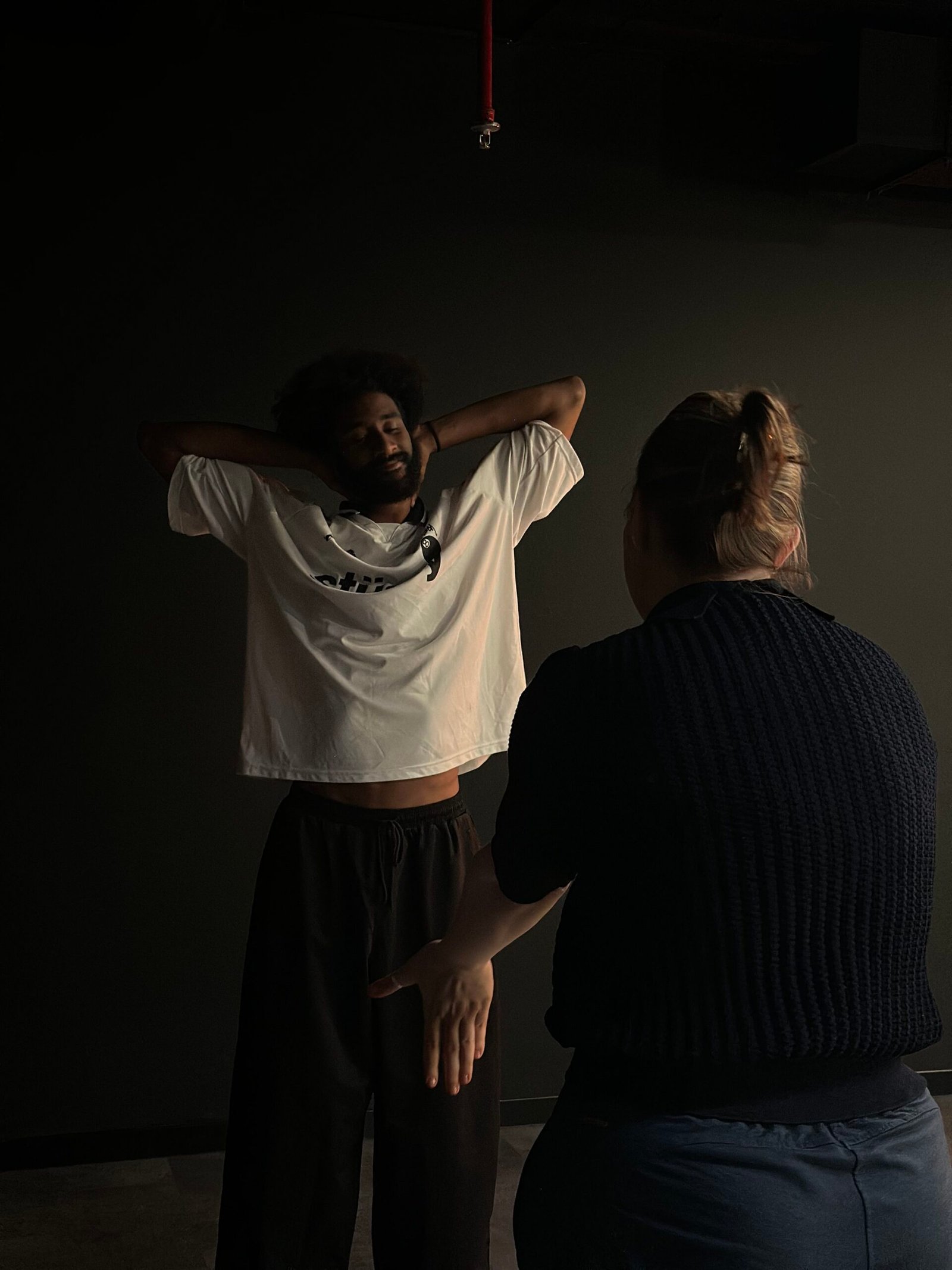 a dramatic image of a woman reaching her hand out to a man with his hands on his head