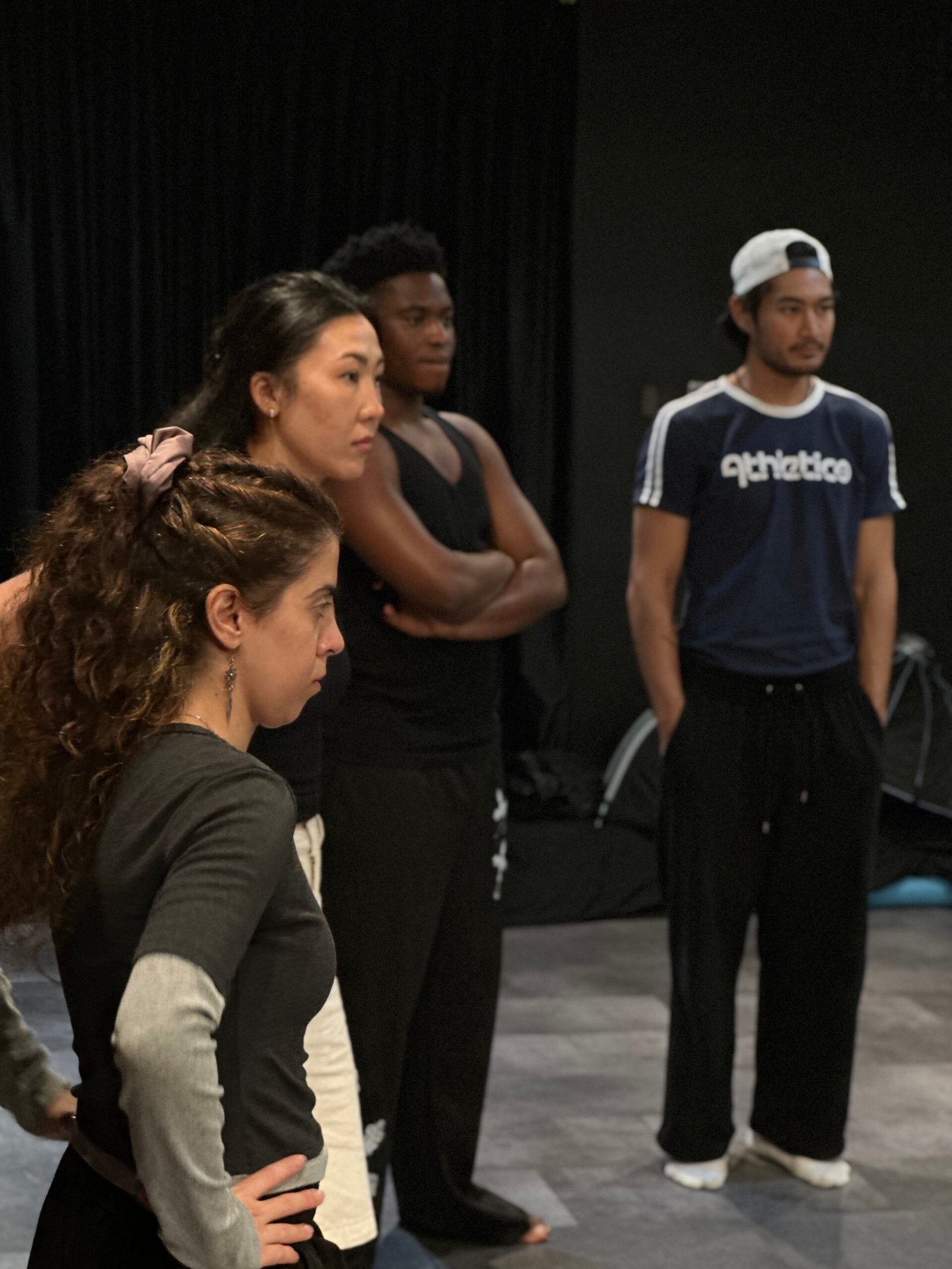 a group of performers looking to the left and listening
