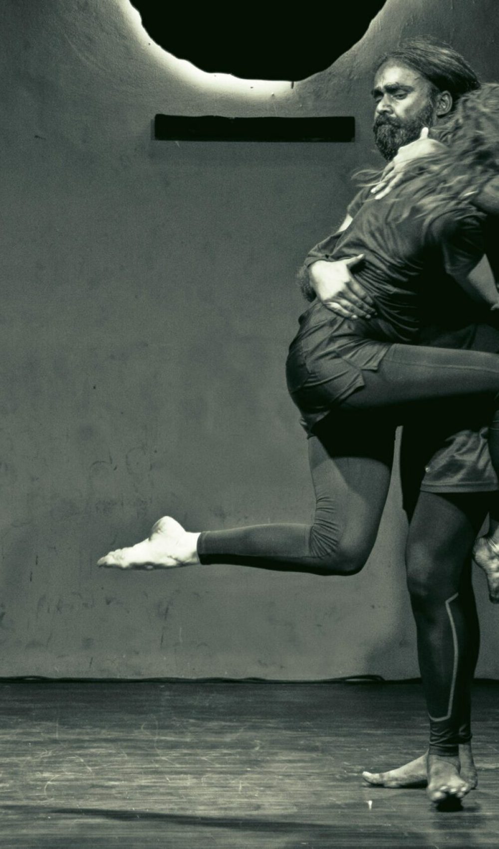 a dancer leaping into another dancer's arms in black and white